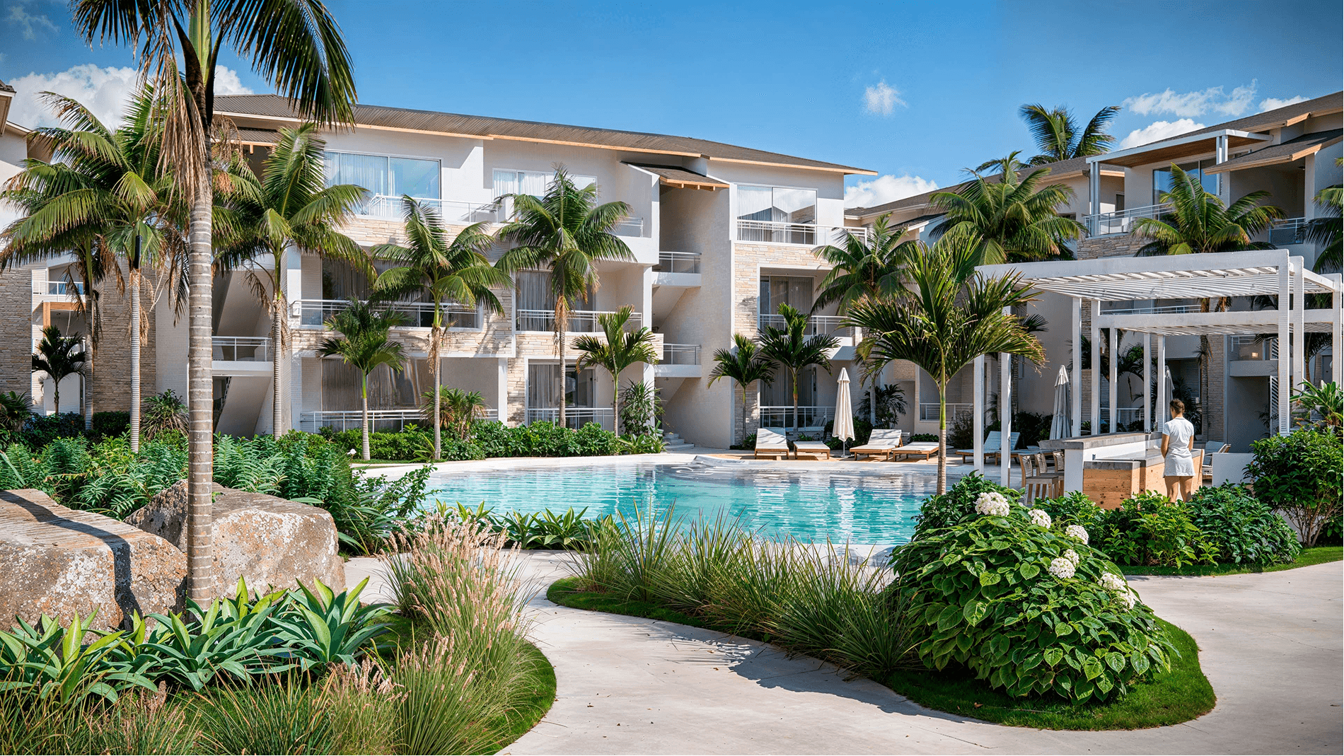Pool area and residents' club with sun loungers and palm trees